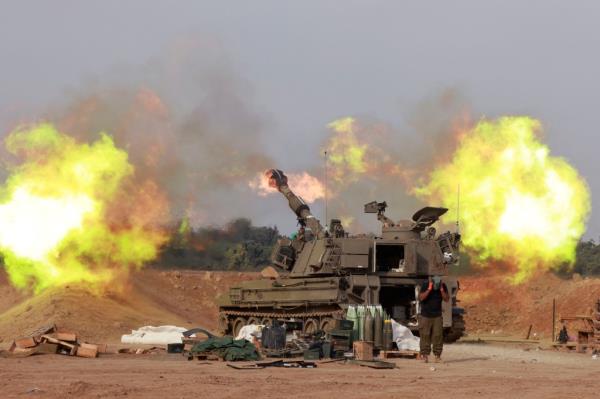 An Israeli army self-propelled artillery howitzer fires rounds from a position near the border with the Gaza Strip in southern Israel on Dec. 7, 2023. 