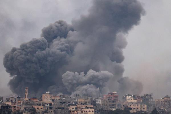 Palestinians evacuate a wounded woman following Israeli airstrikes in Khan Younis refugee camp, southern Gaza Strip on Dec. 7, 2023. 