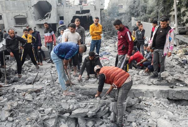 Palestinians assess the destruction to their neighborhood in the Maghazi Palestinian refugee camp in the central Gaza Strip on Dec. 7, 2023. 