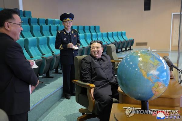 This photo, carried by North Korea's official Korean Central News Agency on Nov. 25, 2023, shows the North's leader Kim Jong-un (R) speaking with officials, as he visited the Natio<em></em>nal Aerospace Technology Administration the previous day to examine photos taken by the country's new military spy satellite (For Use o<em></em>nly in the Republic of Korea. No Redistribution) (Yonhap)