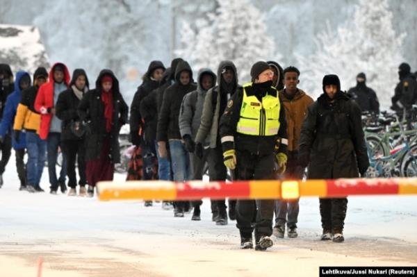 FILE - Finnish Border Guards escort the migrants at the internatio<em></em>nal border crossing at Salla, northern Finland, Nov. 23, 2023. (Lehtikuva/Jussi Nukari via Reuters)