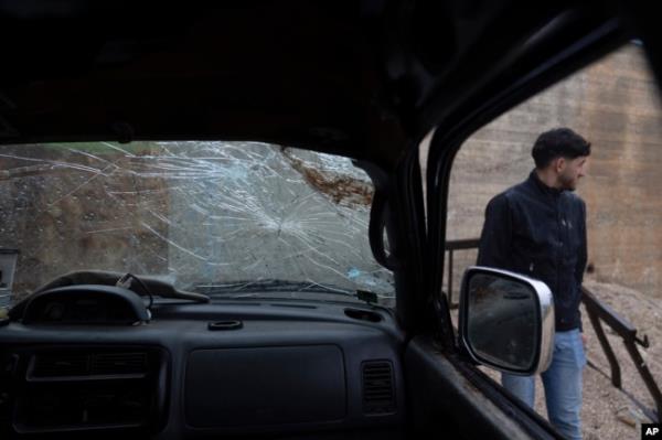 A youth inspects the wrecked truck of Tawfic Abdel Jabbar, a 17-year-old from Louisiana who was fatally shot while he was driving in the family's Palestinian home village, Al-Mazra'a ash-Sharqiya, West Bank, Jan. 23, 2024.