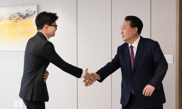 President Yoon Suk Yeol (right) shakes hands with Han Dong-hoon, interim leader of the ruling People Power Party, during their luncheon meeting at the presidential office in Seoul on Mo<em></em>nday in this photo provided by the presidential office. (Yonhap)