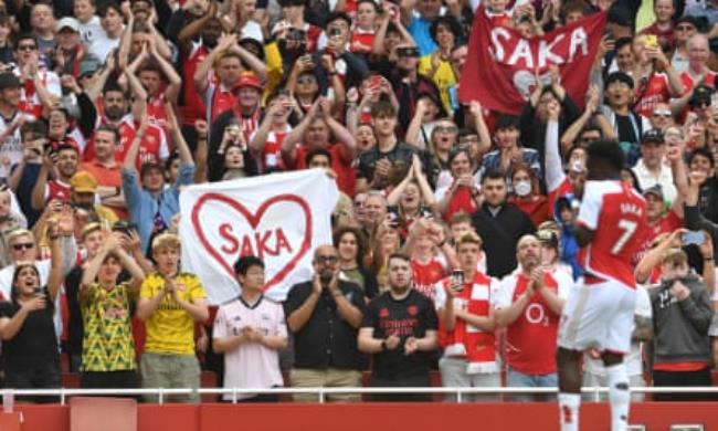 Bukayo Saka celebrates with fans holding up banners with his name after he scored Arsenal’s third goal in their 5-0 demolition of Wolves at the Emirates