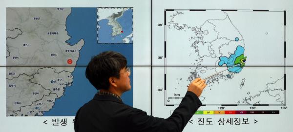 A Korea Meteorological Administration official inspects a map depicting the 4.0 magnitude earthquake that hit Gyeo<em></em>ngju on Thursday. (Yonhap)