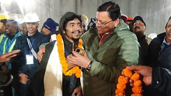 Uttarakhand Chief Minister Pushkar Singh Dhami (C) with the rescued worker inside the tunnel on the Brahmakal Yamunotri Natio<em></em>nal Highway in Uttarkashi, India, 28 November 2023