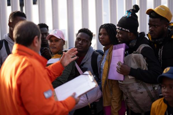 A Mexican immigration official speaks to migrants, including many from Haiti