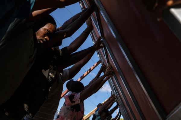 Haitians raise a me<em></em>tal gate in an attempt to barricade themselves from gangs