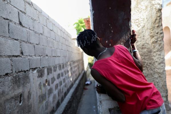 A man looks at a dead body in Port au Prince