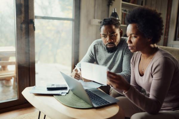 couple looking worried while reading bills