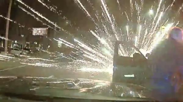 A screengrab from the footage shows flares exploding over a police vehicle.