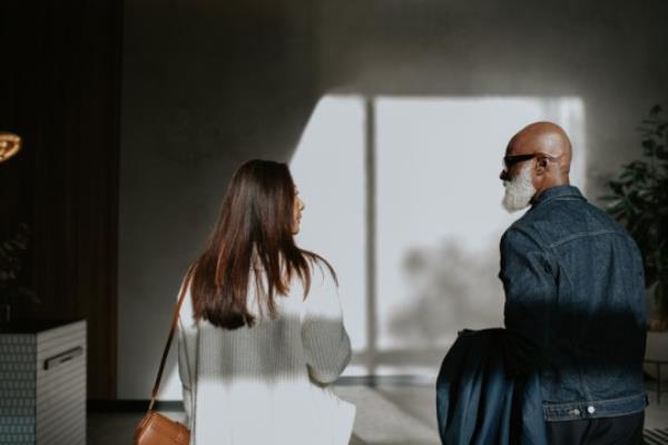 Co<em></em>nceptual image of a man and a woman standing next to each other, and walking away from the camera.