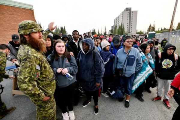 People line up outside of a local school to register to be evacuated, as wildfires threatened the Northwest Territories town of Yellowknife, Canada, August 17, 2023. REUTERS/Jennifer Gauthier TPX IMAGES OF THE DAY