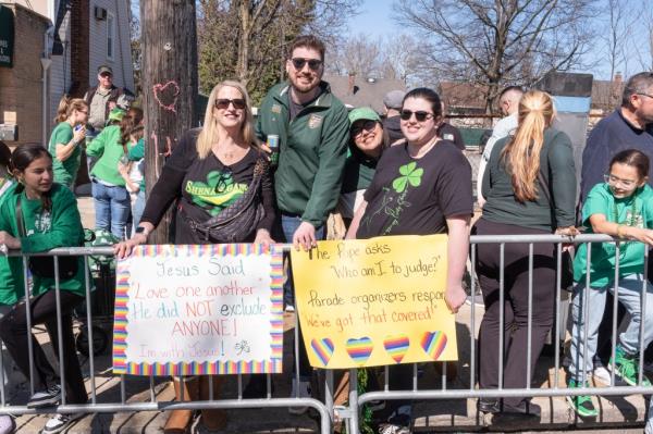 The Buckley family holding up signs at the side of the parade route.