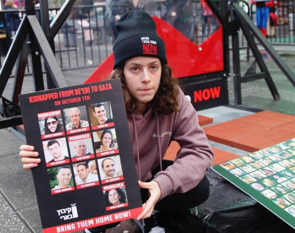 Hila Rotem Shoshani holds a poster of hamas hostages 