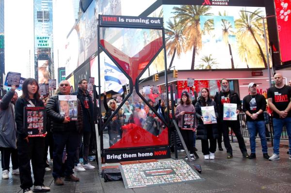 A sand clock in Times Square represents the hostages' 100-day ordeal.