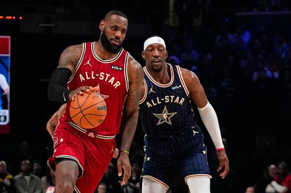 LeBron James drives by Bam Adebayo.