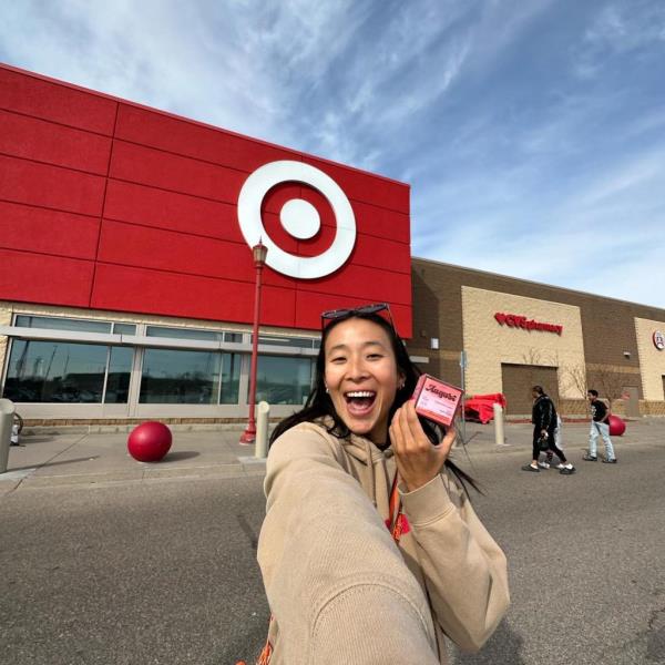 Nadya Okamoto stands outside of a Target store holding a box of August tampons