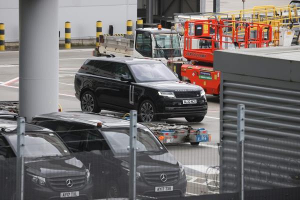 Prince Harry leaves Windsor suite at Heathrow Terminal 5 and heads to see his father for cancer treatment, a black car parked in a parking lot.