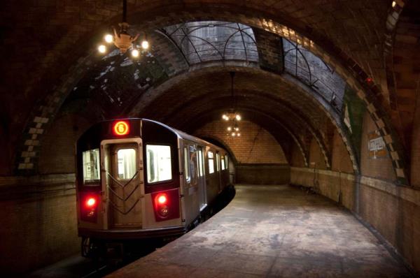 A modern 6 train passes through the Old City Hall station.