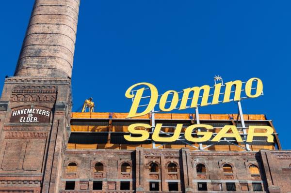 Exterior Domino Sugar Refinery with signage and chimney. 