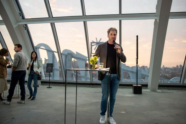 Jed Walentars holding microphone in penthouse at the Refinery at Domino. 