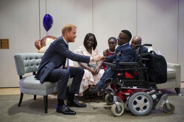 Harry, left, speaks to Ruky Anighoro, front right, during the annual WellChild Awards 2023.