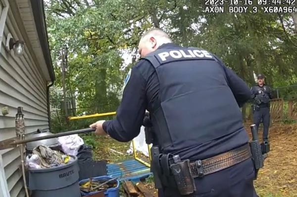 Akron Police seen on bodycam footage using a shovel to pry a shed open. 