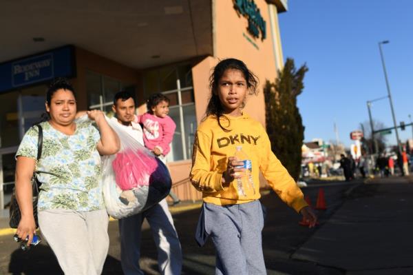 A family is leaving the largest migrant encampment on 27th Ave. between Zuni St. and Alcott St. to another shelter in Denver, Colorado on Jan. 3.