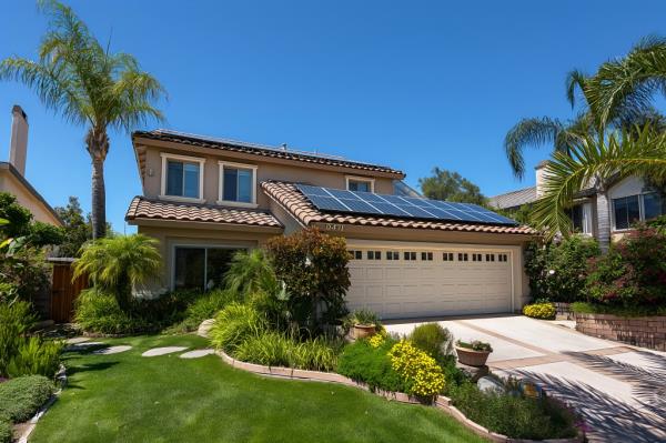 Modern solar panels installed on a house roof under clear blue sky in San Diego