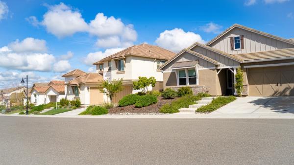 Row of single family homes in Northern California on a clear day with a street in the background