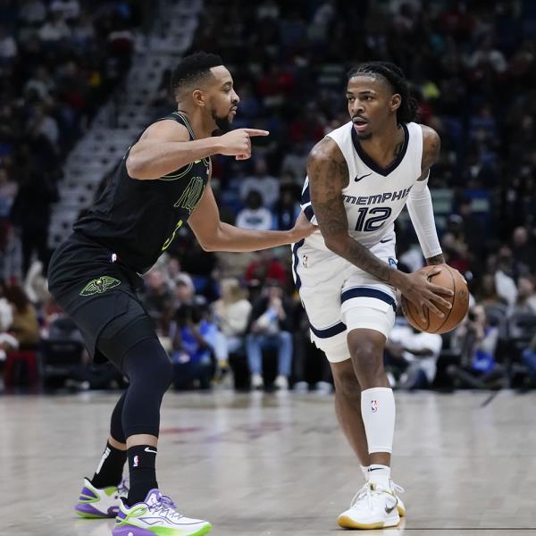 Memphis Grizzlies guard Ja Morant (12) looks to pass around New Orleans Pelicans guard CJ McCollum (3) in the first half of a game in New Orleans on Dec. 19, 2023. 