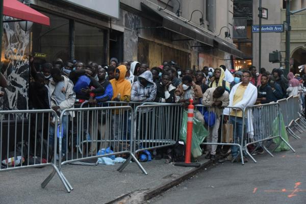 Migrants stand in line at the Roosevelt Hotel.