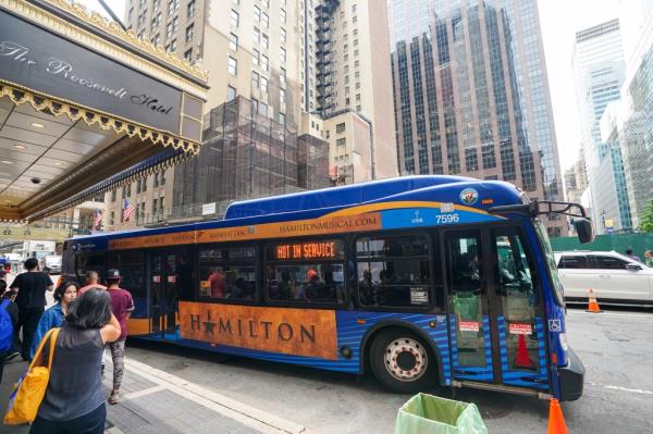 a<em></em>bout 20 migrants leave on a city bus from the Roosevelt Hotel, which was being used as temporary housing.