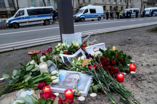 Portraits of Alexei Navalny lay on flowers and candles as police guard the area while people protest in front of the Russian embassy in Berlin, Germany.