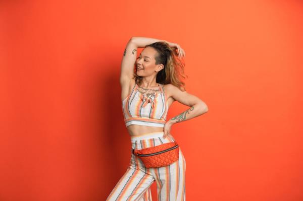 A woman posing with a fanny-pack on her waist.