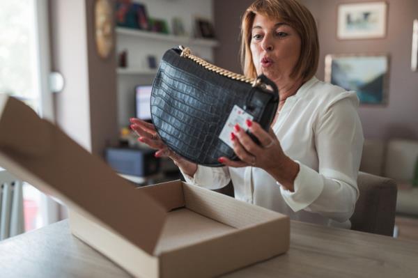 Happy woman excited over her new bag.