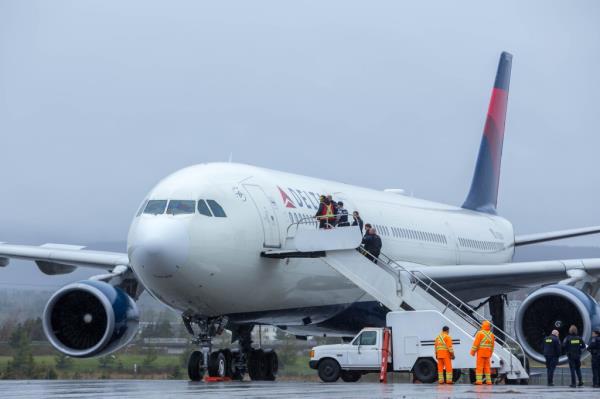 Canadian authorities are seen entering Delta Airlines flight 97 after it was forced to make a emergency landing due to an unruly passenger on Friday.