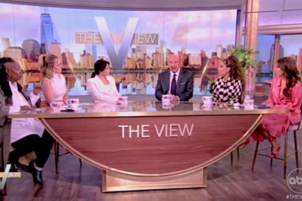 Dr. Phil sitting at a table on The View talk show with Sunny Hostin discussing Covid lockdowns.