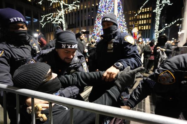 A man is tackled by police officers as Pro-Palestine protestors gather outside the News Corporation building during a 