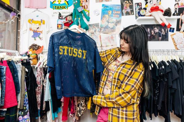 Hayley Giuca inside Rogue, on Stanton Street  looking at a Stussy top.