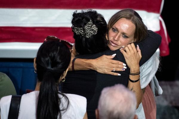 A woman holds late US Marine Kareem Grant Nikoui's mother Shana Chappell (R) as people ho<em></em>nor his memory during a memorial ceremony at Harvest Christian Fellowship in Riverside, USA, 18 September 2021. 