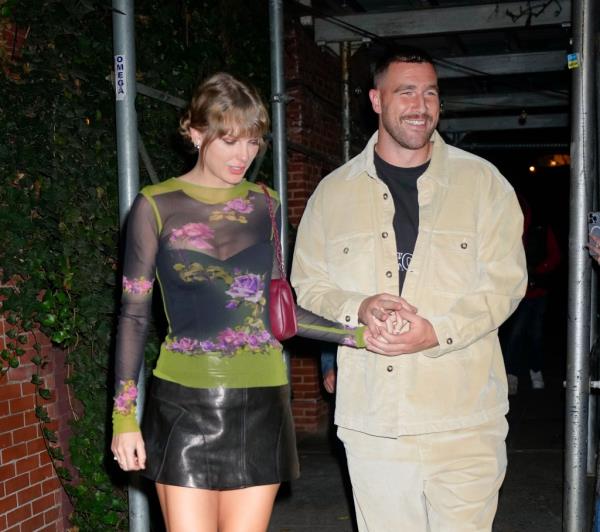 Taylor Swift and Travis Kelce holding hands.