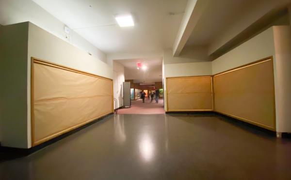 A museum exhibition with blinds covering glass display cases