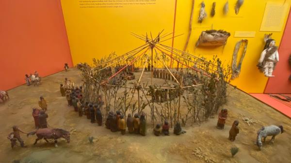 A model of Native Americans apparently erecting a circular structure.