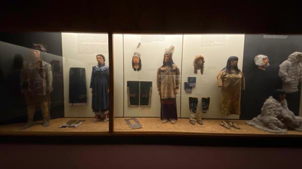 A museum exhibition showing Native American costumes on mannequins.