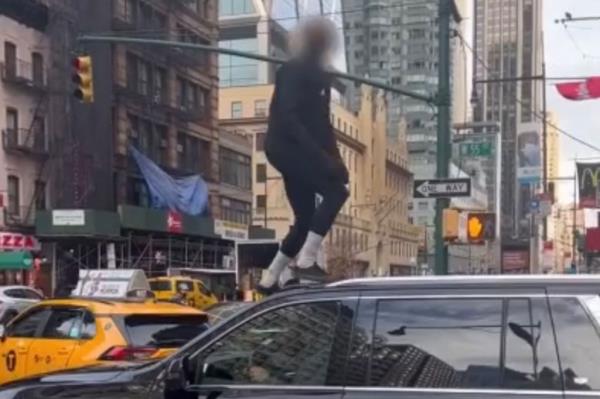 Person stands on top of car