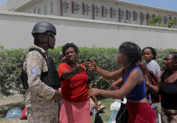 Women argue with an officer of the Haitian Natio<em></em>nal Police after the police cleared a camp of people escaping the threat of armed gangs, in front of the U.S. Embassy, in Port-au-Prince, Haiti July 25, 2023