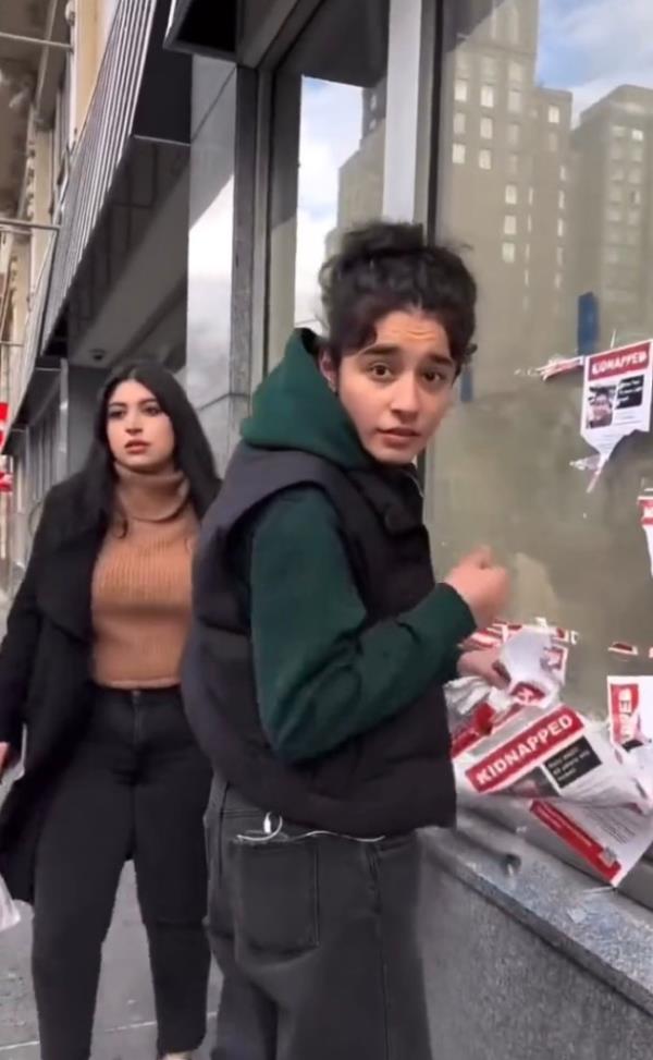 Woman holding Hamas hostage posters