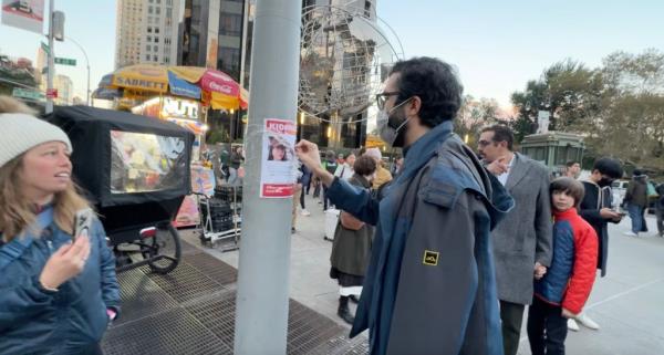 man tearing down hostage poster